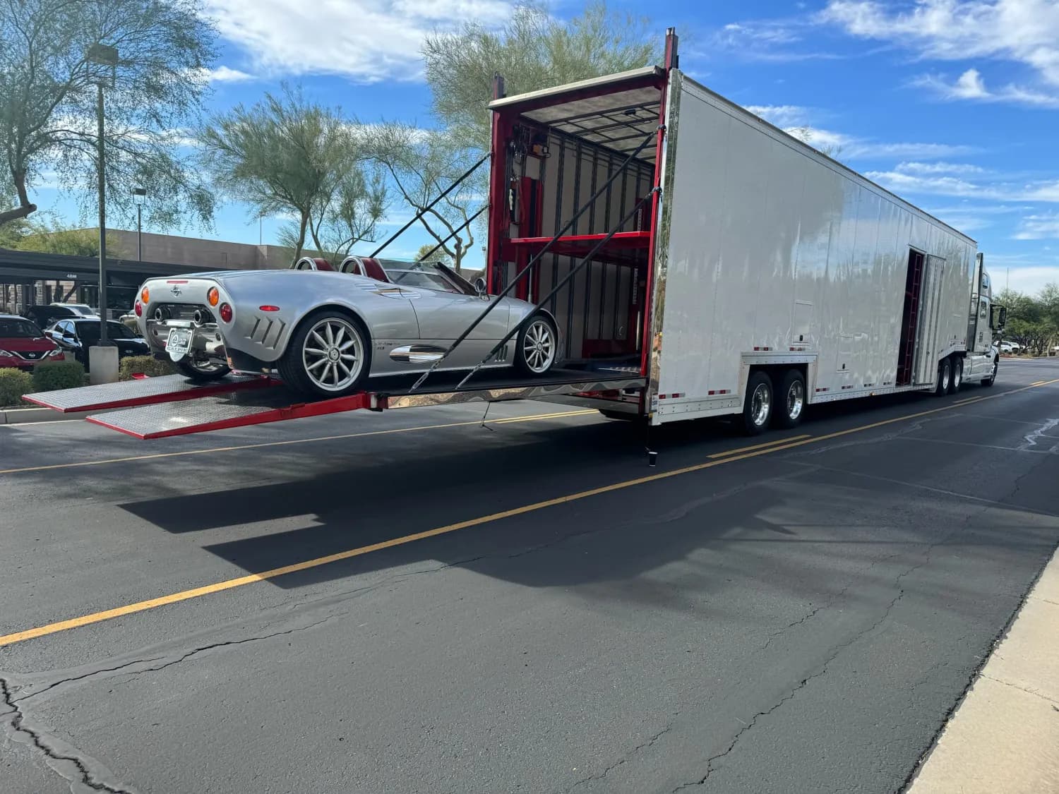 White coupe being loaded into an enclosed trailer
