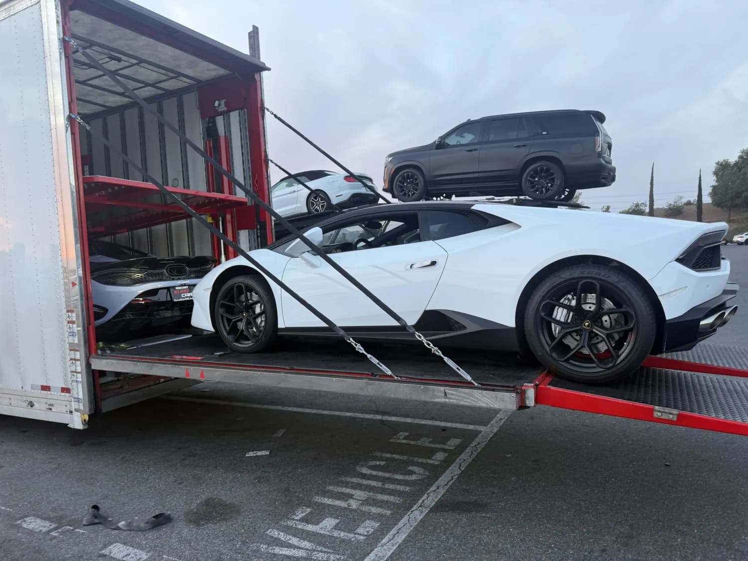 White sports car on the ramp of an enclosed carrier